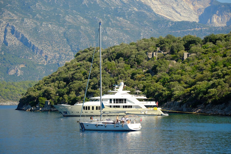 Sailing boats anchored in a picturesque Mediterranean bay surrounded by lush mountains.