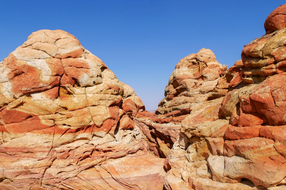 Stunning red sandstone rock formations against a clear blue sky in a desert landscape.