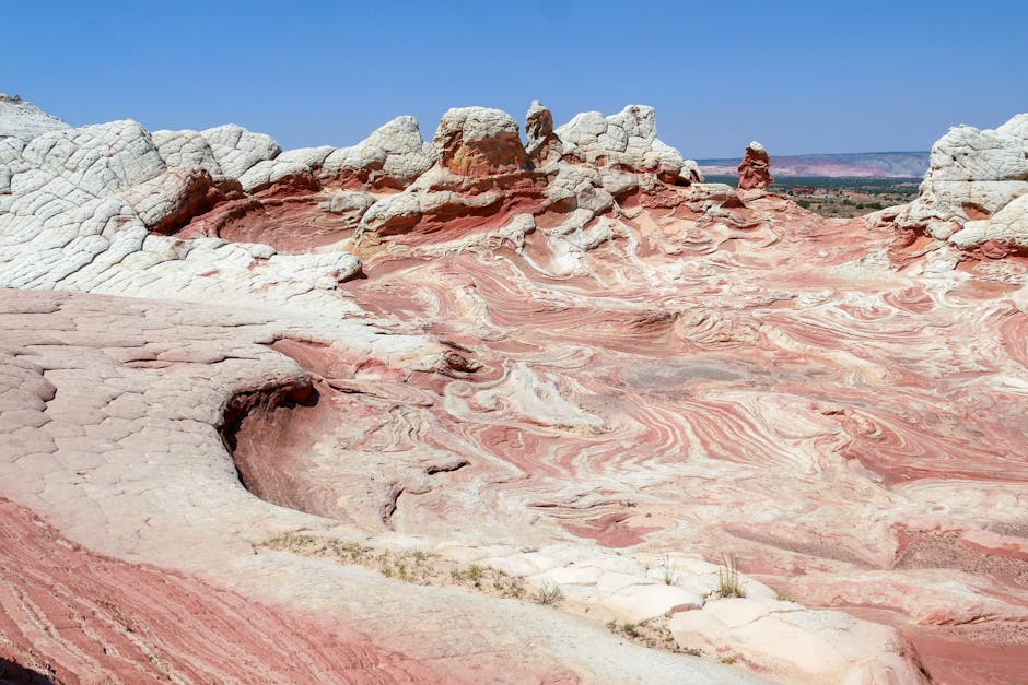 Discover the mesmerizing swirl patterns of eroded sandstone formations under a clear blue sky.